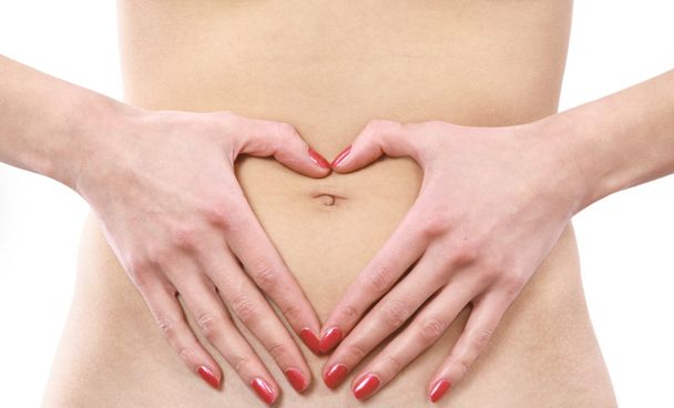 Love - A woman's hands forming a heart symbol on belly - Valokuva, kuva