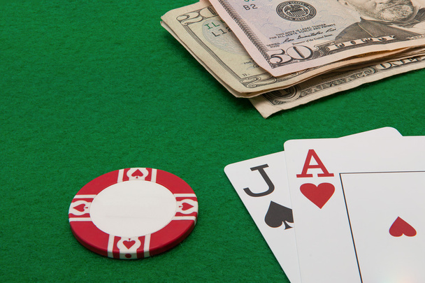 Blackjack hand with Dollar notes and chip on green background - Foto, Imagem