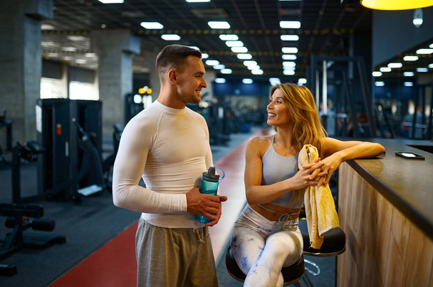 Sportliches Paar entspannt sich an der Theke in der Fitnessbar - Foto, Bild