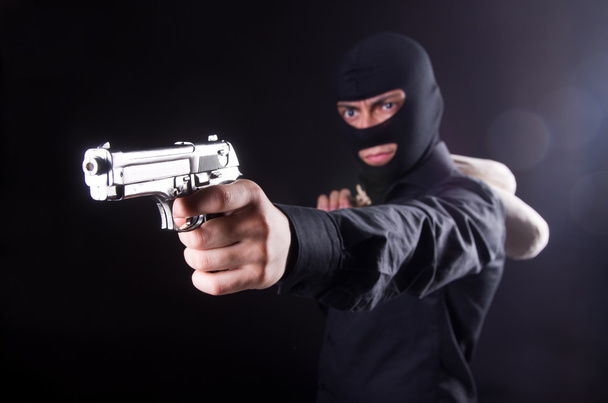 Homme portant une cagoule avec pistolet
 - Photo, image