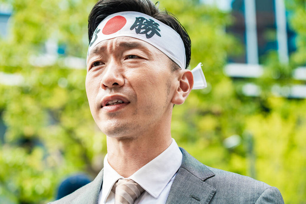 Ein Kandidat mit Stirnbändern, um seine Stimme zu erheben - Foto, Bild