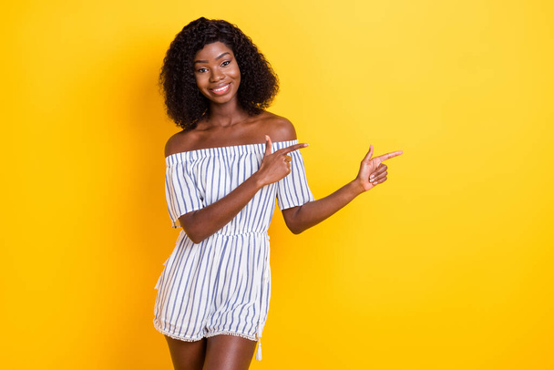 Portrait of attractive cheerful girl demonstrating copy empty blank place space ad isolated over bright yellow color background - Foto, immagini