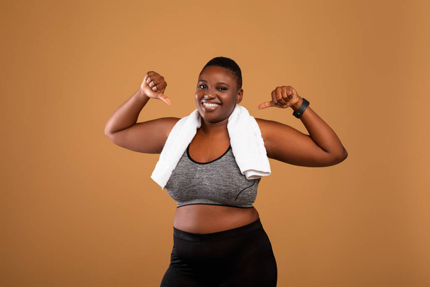 Chubby black woman in sportswear pointing at herself - Foto, Imagen