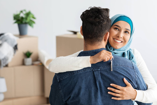 Felice donna musulmana con chiave che abbraccia suo marito - Foto, immagini