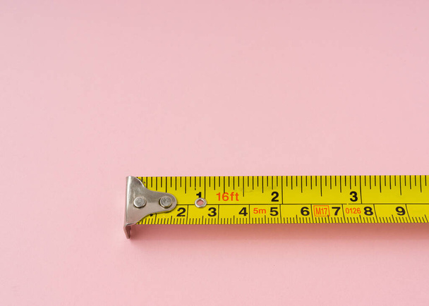 Measuring tape with centimeters and inches on pink background. - Photo, Image