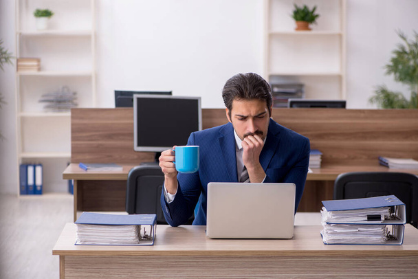 Young male employee drinking coffee during break - Foto, immagini