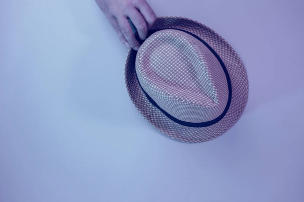  Hand holding Beautiful straw hat on a gray  background. - Photo, Image