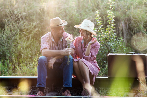 couple in love cowboys with suitcase near railway - 写真・画像