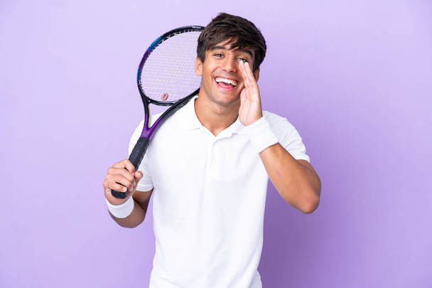 Красивый молодой теннисист, изолированный на заднем плане, кричащий с открытым ртом - Фото, изображение
