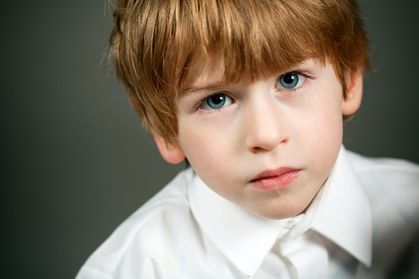 Little serious boy portrait on dark background - Фото, изображение