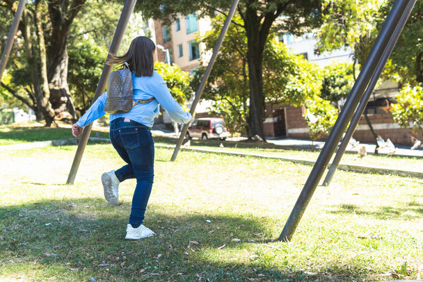 Petite fille blonde avec un sac à dos courant dans un parc - Photo, image
