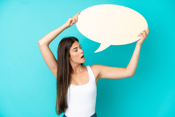 Young Brazilian woman isolated on blue background holding an empty speech bubble - Photo, Image