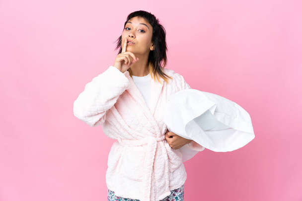 Young Uruguayan woman in pajamas over isolated pink background doing silence gesture - Photo, Image