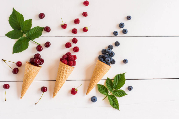 Fruit background. Fresh fruits and berries in waffle cones. Summer concept. Flat lay, top view - Photo, Image