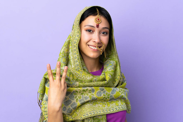 Indian woman isolated on purple background happy and counting three with fingers - Zdjęcie, obraz
