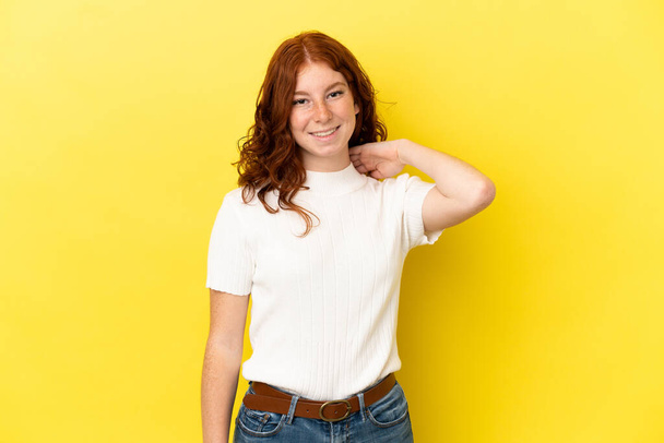 Genç kızılımsı kadın sarı arka planda izole edilmiş gülüyor. - Fotoğraf, Görsel