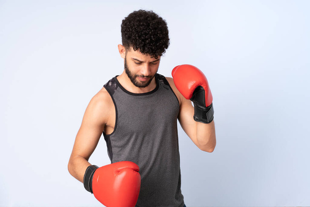 Young Moroccan man isolated on blue background with boxing gloves - Foto, Bild
