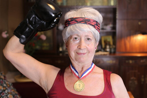 portrait en gros plan de femme mature en costume de boxeur avec médaille d'or à la maison, concept de célébration d'Halloween - Photo, image