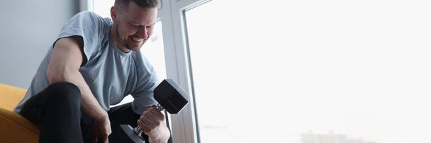 Man does exercises with dumbbells for biceps - Foto, Imagem