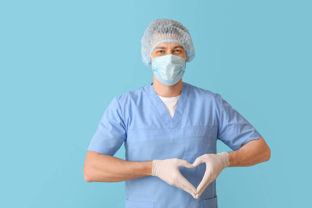Cardiologist making heart with his hands on color background - Foto, Imagem