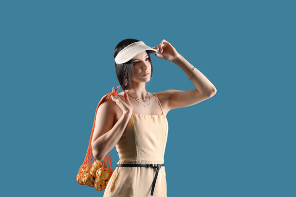 Mujer joven con estilo con bolsa de cuerda en el fondo de color - Foto, imagen