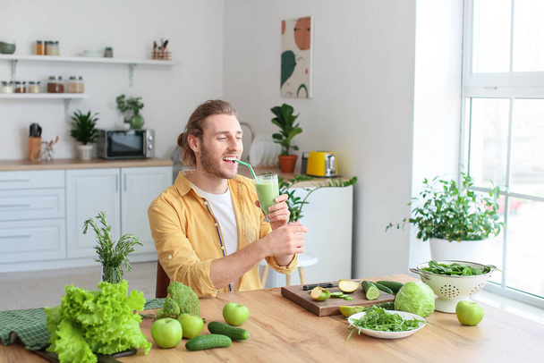 Молодий чоловік п'є здорову зелену смужку на кухні
 - Фото, зображення