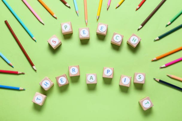 Kockák szöveges SPEECH THERAPIST és ceruzák színes háttér - Fotó, kép
