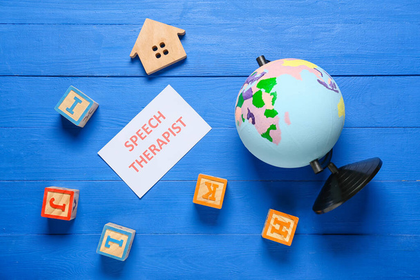 Бумага с текстом SPEECH THERAPIST и игрушки на цветном деревянном фоне - Фото, изображение