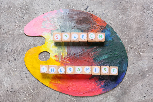 Kockák szöveges SPEECH THERAPIST és festék paletta grunge háttér - Fotó, kép