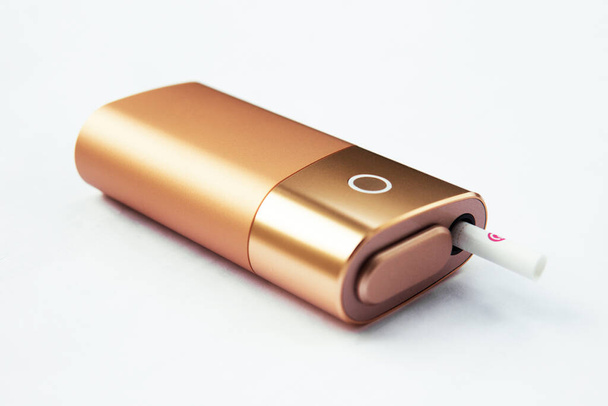 Eine neue Art der elektronischen Zigarette. IQOS Tabakheizsystem. Lügen auf weißem Hintergrund Close-up-Tool für sicheres Rauchen von Tabak - Foto, Bild