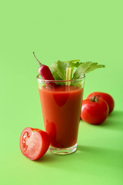 Glass of bloody mary cocktail garnished with cilantro, red chili pepper and tomato on color background - Φωτογραφία, εικόνα