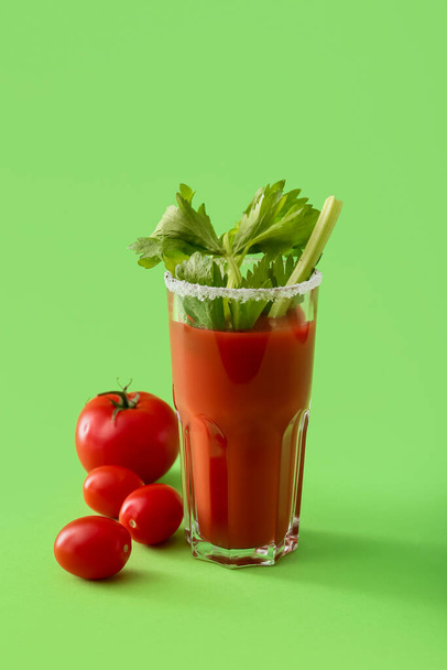 Glass of bloody mary cocktail garnished with cilantro and tomatoes on color background - Photo, Image