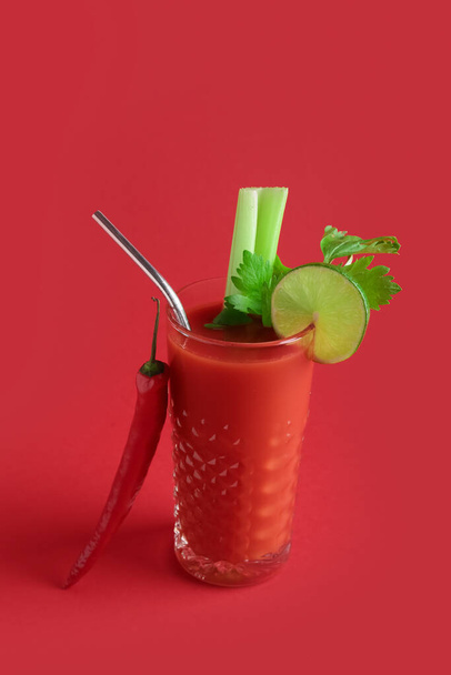 Glass of bloody mary cocktail and red chili pepper on color background - Photo, Image