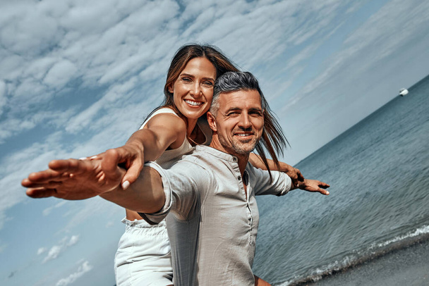 Cheerful young couple enjoying the summer time on the beach. Close up view - Fotoğraf, Görsel