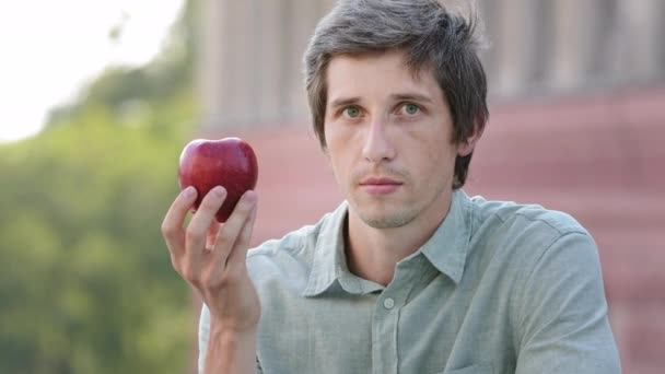 Ο νεαρός άνδρας της χιλιετίας θέλει να φάει μήλο, αλλά δεν μπορεί. Αστεία αστεία Guy, δείχνει παντομίμα δεν μπορεί να δαγκώσει φρούτα. Βιταμίνες, διαλείπουσα νηστεία, διατροφή χωρίς υδατάνθρακες, ανέφικτος στόχος - Πλάνα, βίντεο