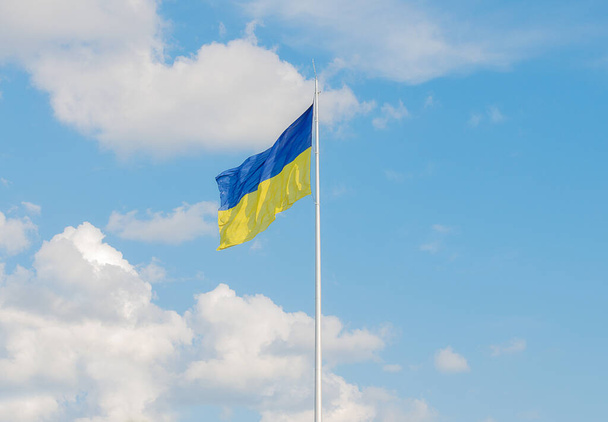 Шовк махає прапором України проти блакитного неба. Національний символ України - Фото, зображення