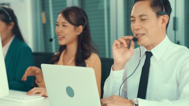 Biznesmeni noszący słuchawki pracujący aktywnie w biurze - Materiał filmowy, wideo