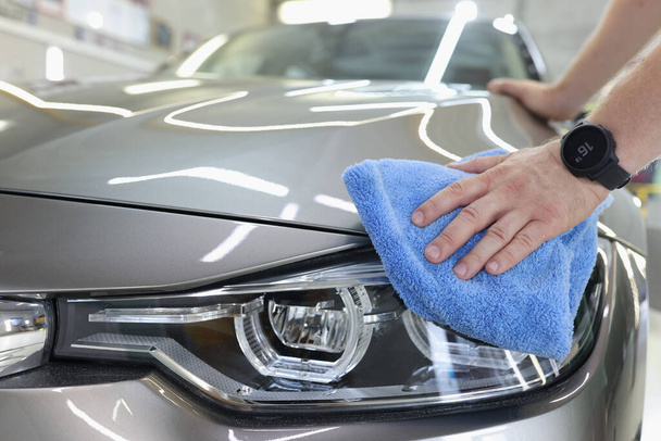 Man schoonmaken van een auto met microvezel doek closeup - Foto, afbeelding