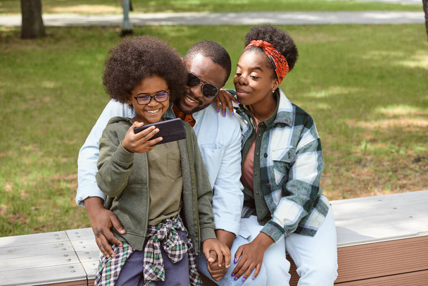 Чарівний хлопчик зі смартфоном фотографує свою сім'ю
 - Фото, зображення
