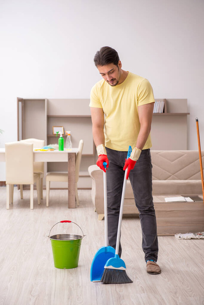 Young male contractor cleaning the house - Zdjęcie, obraz