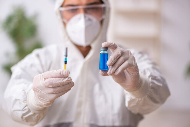 Jeune chimiste masculin dans le concept de vaccination pendant une pandémie - Photo, image