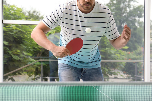 Man playing ping pong indoors, closeup view - Zdjęcie, obraz