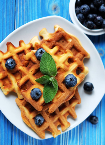 Homemade Belgian waffles served with fresh berries on white plate over wooden background, close up. Top view. Flat lay,Tasty. Sweet. - Foto, Bild