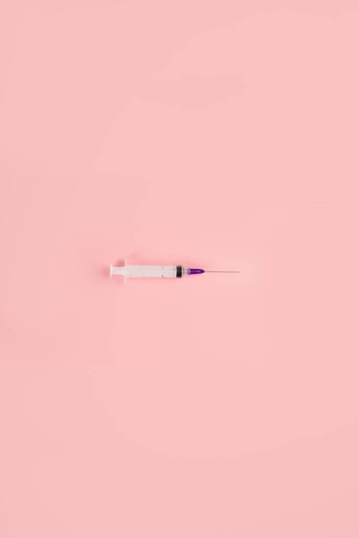 Jeringas colocadas sobre fondo rosa. Concepto médico y vacunación. Vista superior, plano, espacio para copiar - Foto, Imagen
