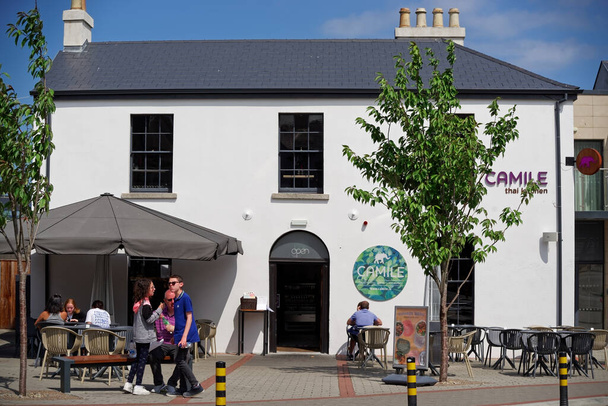 GREYSTONES, IRELAND - Jul 02, 2021: The Camile Thai restaurant with customers eating outdoor on sunny summer day in Greystones, County Wicklow, Ireland. - Zdjęcie, obraz