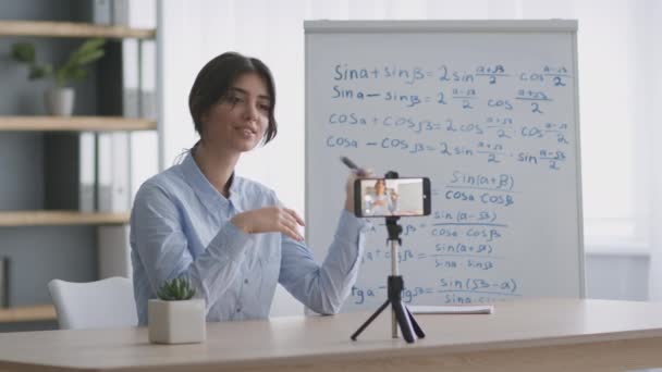 若い陽気な数学教師録画ビデオのためのブログ上のスマートフォン,数学式と教室に座って - 映像、動画