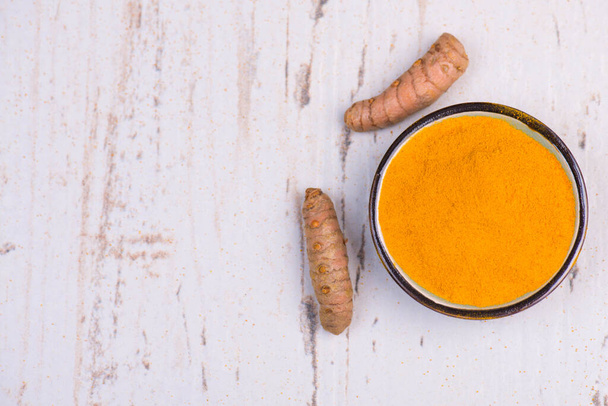 Curcuma spice, fresh roots and powder,empty copy space for text, textured background,isolated - Photo, Image