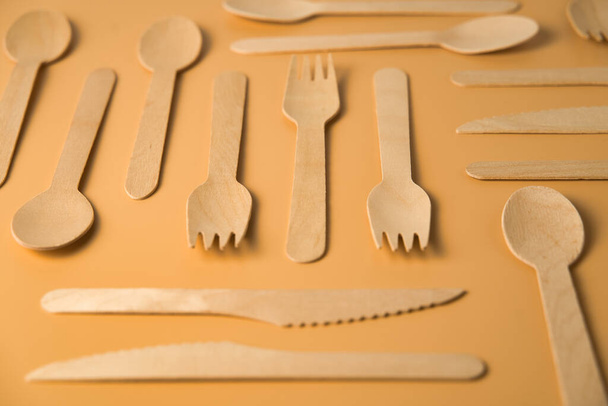 Design of disposable wooden teaspoons on light orange background. Recycling concept. - Photo, Image
