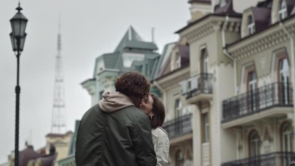 Şehir caddesinde öpüşen aşk çifti. Mutlu erkek ve kadın dışarıda buluşuyorlar.. - Video, Çekim