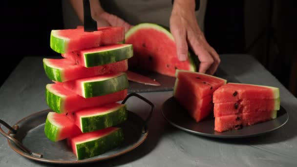 Witte vrouw snijden plakken van rijpe watermeloen met mes en zetten in kom.  - Video